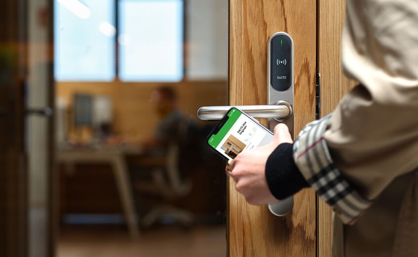 En håndholdt enhed bruges ved en elektronisk dørlås